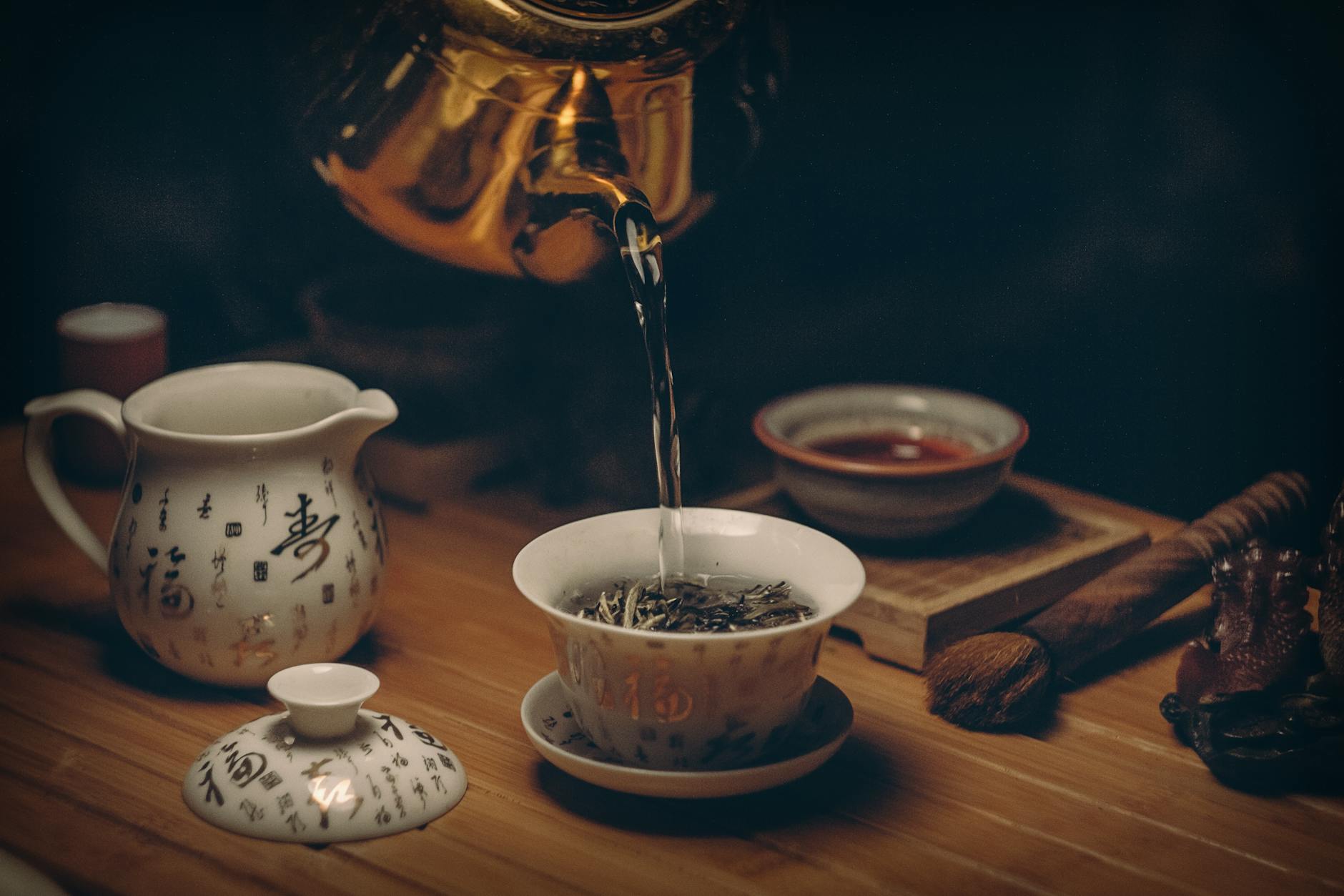 benefits of herbal tea matcha tea ritual gold kettle pouring hot water on cup of tea